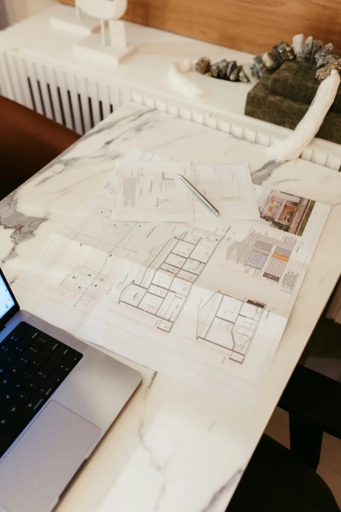 Architectural plans on a marble desk during a design consultation